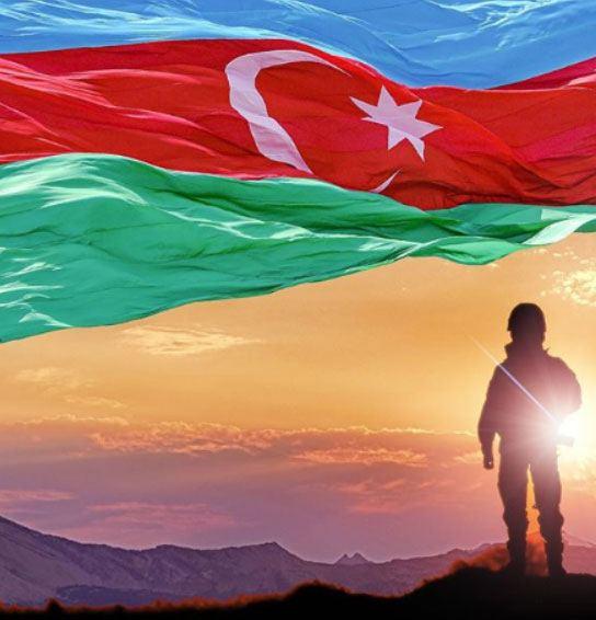 MoD: Azerbaijani soldier moving towards another target with weapon in one hand and flag on other